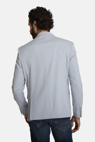 Blauwe blazer van DELAHAYE, klassieke pasvorm, gedragen met een spijkerbroek, achtergezicht.