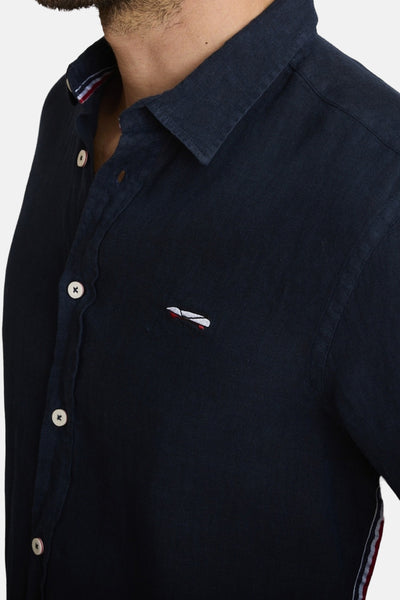 Blauwe blouse van DELAHAYE met witte knopen en een klein geborduurd logo.