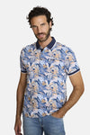 Polo bleu de DELAHAYE, à motifs tropicaux, porté avec un jean.