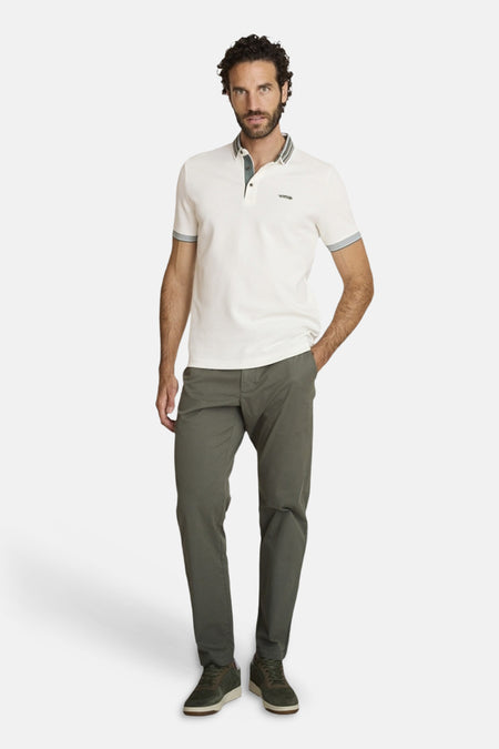 Polo écru de DELAHAYE, manches courtes avec bordures grises, porté avec un pantalon olive et des baskets.