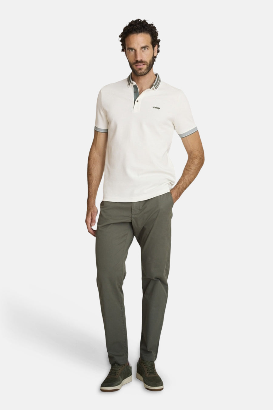 Polo écru de DELAHAYE, manches courtes avec bordures grises, porté avec un pantalon olive et des baskets.