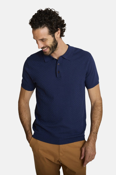 T-shirt bleu à manches courtes de DELAHAYE avec motif texturé losanges porté avec un pantalon marron.
