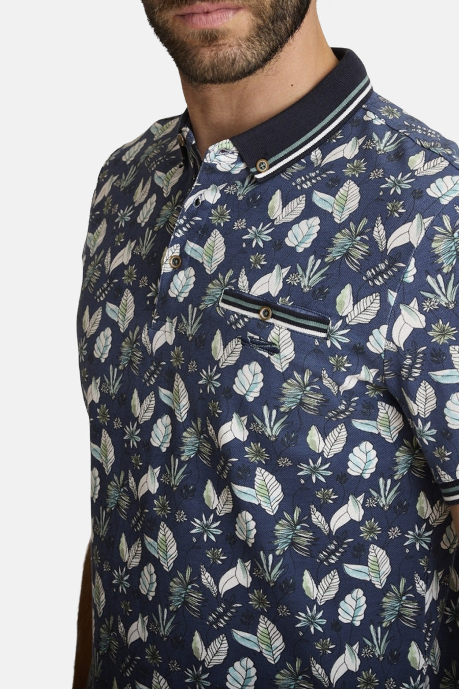 Polo bleu de DELAHAYE avec un imprimé de feuilles et détails rayés au col et à la poche.

