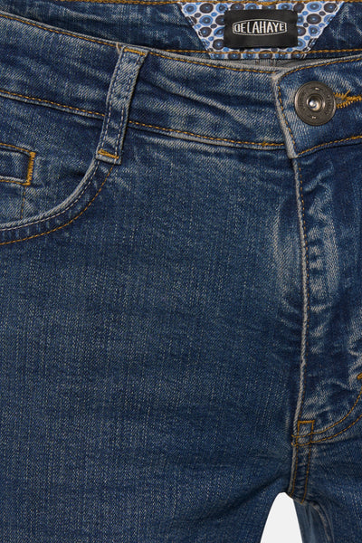 Jean droit bleu par DELAHAYE avec détail de couture apparente et doublure à motifs circulaires.
