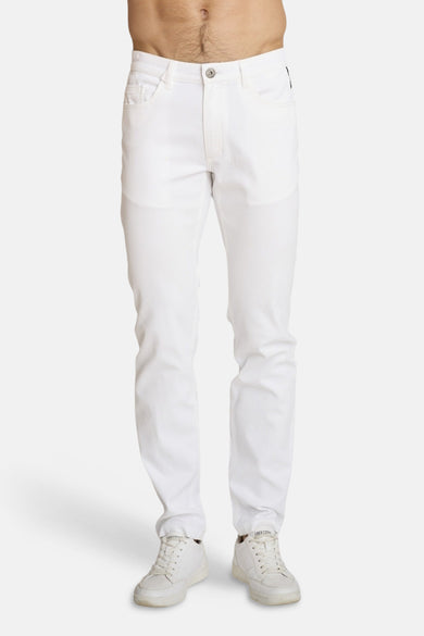 Witte chino van DELAHAYE, van achteren gezien, met achterzakken en witte sportschoenen.