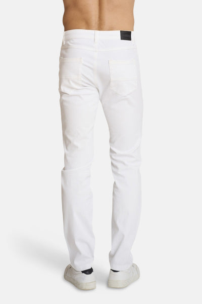 Chino blanc de DELAHAYE, vu de dos, avec poches arrière et chaussures de sport blanches.