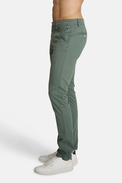 Green chino pants by DELAHAYE, slim fit with front pockets and button fly, side view on model wearing white sneakers