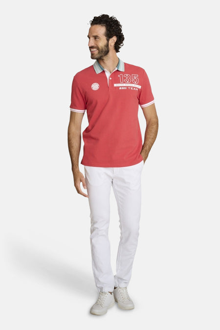 Chino blanc de DELAHAYE porté avec un polo rouge à détails contrastés et des baskets blanches.
