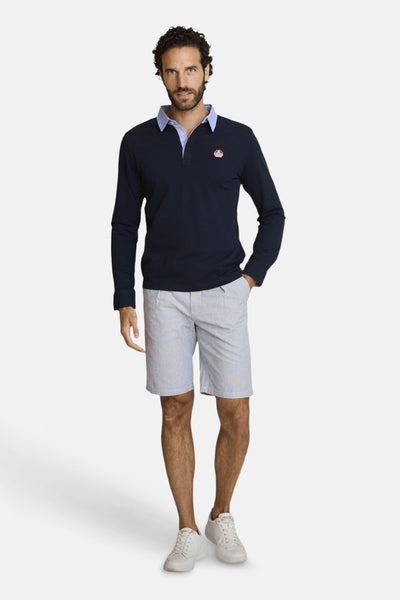 Light blue textured Bermuda shorts by DELAHAYE, featuring a relaxed fit and subtle striped pattern, worn with a navy long-sleeve polo and white sneakers in a full-length front view.