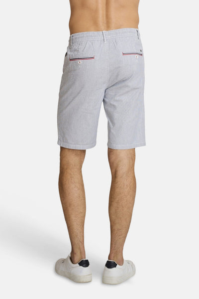 Light blue striped Bermuda shorts by DELAHAYE, back view with red and navy trim on pockets, worn with white sneakers