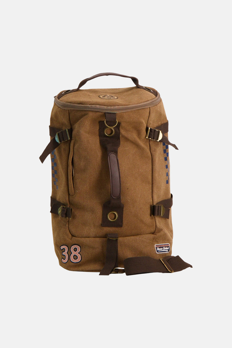 Beige canvas backpack with brown straps and brass buckles, featuring blue checkered side accents and number 38 patch, front view