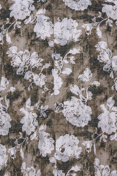 Multicolored long-sleeve blouse with white floral pattern on brown and black textured fabric, featuring silver buttons down the front, close-up view