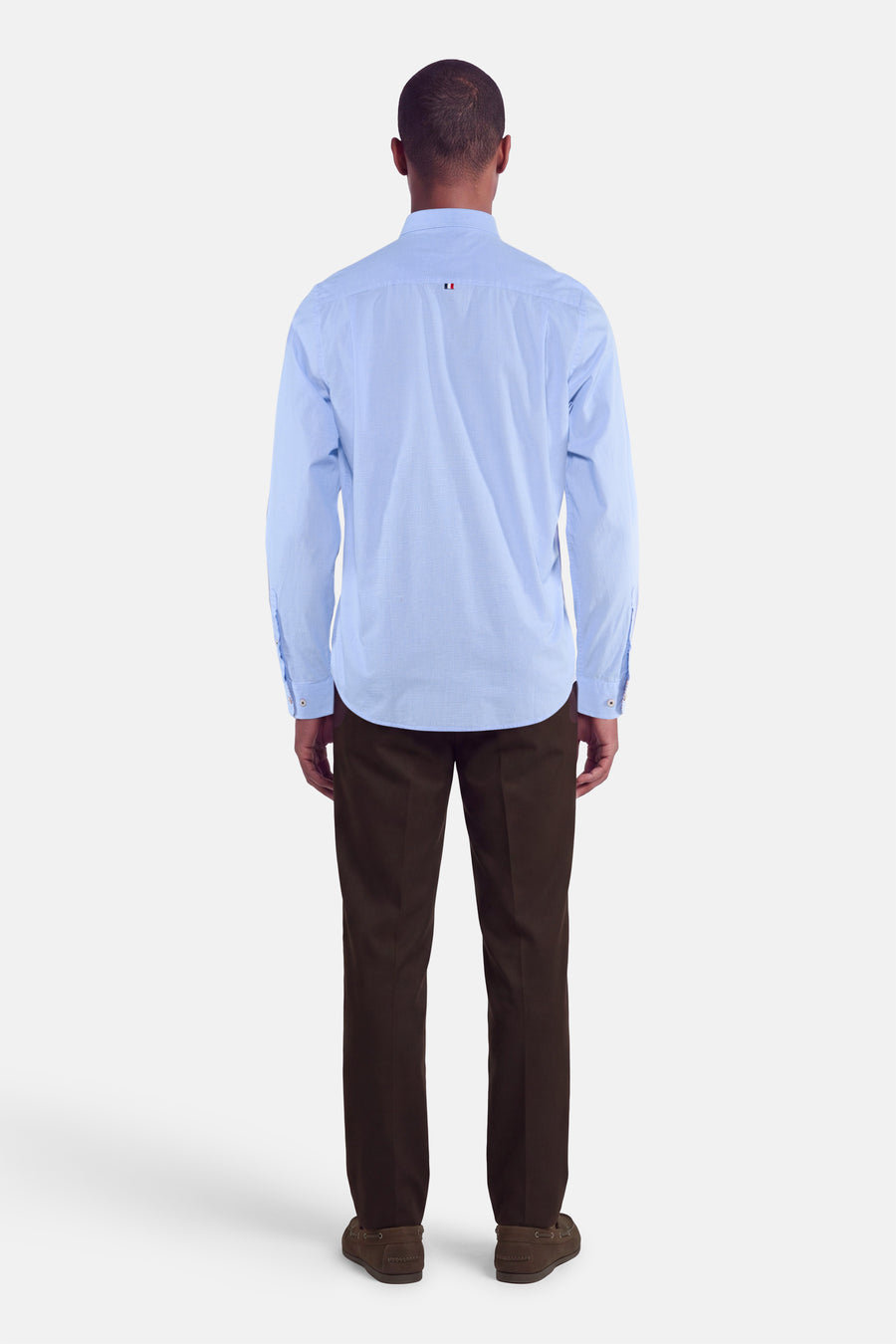 Chemise bleue à manches longues de DELAHAYE, vue dos, avec col classique et poignets boutonnés, portée avec pantalon marron foncé.