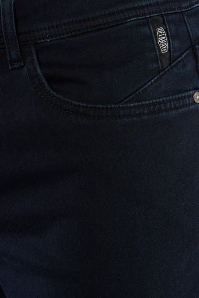 Dark blue chino pants by Delave, close-up back view showing textured twill fabric and branded pocket tab.