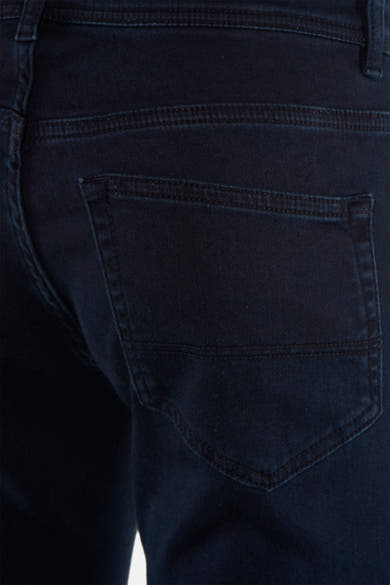 Dark blue chino pants back view with stitched pocket and textured fabric, close-up detail
