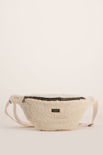 Sac banane en fausse fourrure écru de BARTS, avec une fermeture éclair noire et une sangle beige réglable.
