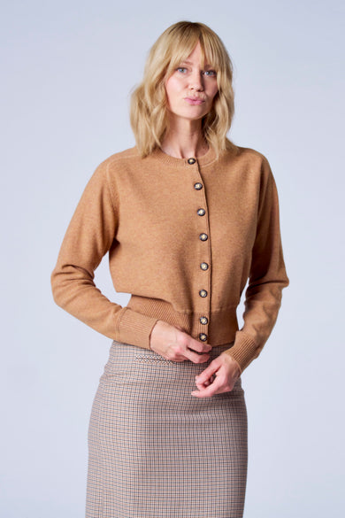 Gilet marron de TERRE BLEUE, avec une jupe à carreaux et des boutons décoratifs.