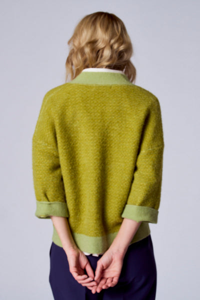 Groen vest van TERRE BLEUE, driekwartmouwen, gemêleerde textuur, gedragen met een marineblauwe broek.