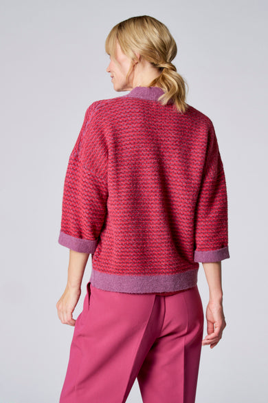 Gilet violet de TERRE BLEUE en tricot à motif texturé, porté avec un pantalon rose.
