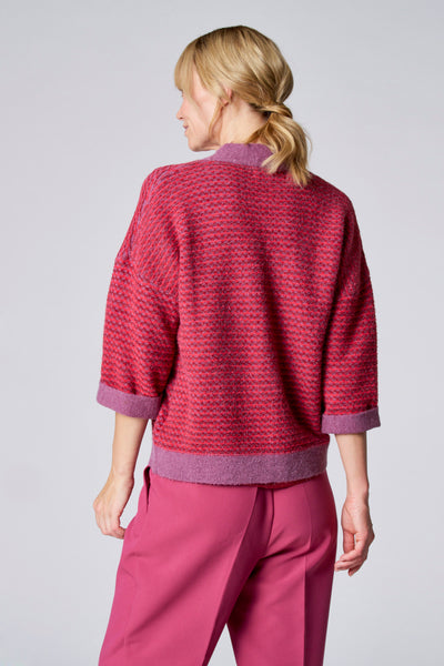 Gilet violet de TERRE BLEUE en tricot à motif texturé, porté avec un pantalon rose.