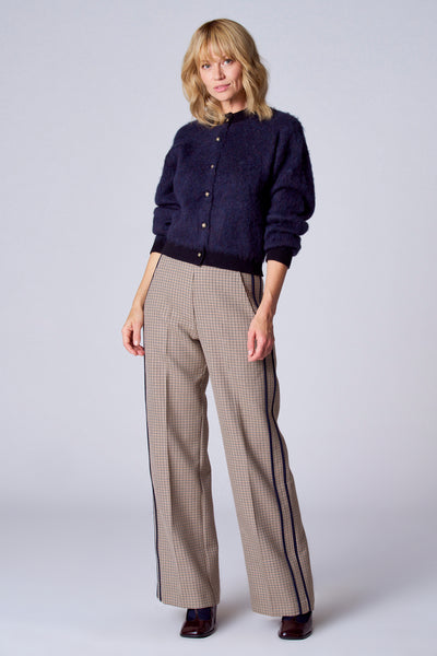 Gilet bleu de TERRE BLEUE, avec des boutons dorés, porté avec un pantalon à carreaux.