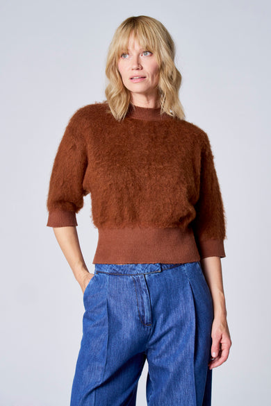 Pull brun du TERRE BLEUE, en texture duveteuse, porté avec un pantalon large bleu denim.

