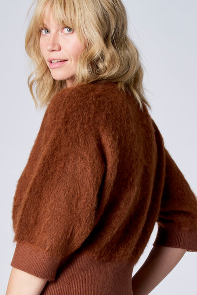 Pull brun en mohair de TERRE BLEUE avec manches bouffantes et texture duveteuse.
