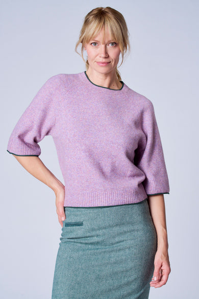 Pull violet de TERRE BLEUE avec bordure verte, porté avec une jupe crayon verte texturée.
