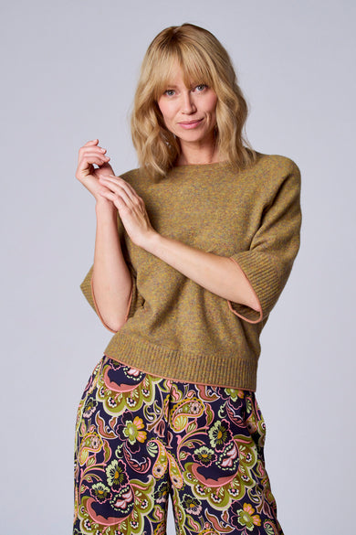 Groene trui in tricot van TERRE BLEUE met korte mouwen en een broek met bloemenpatroon.