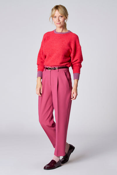Short rose de TERRE BLEUE, porté avec un pull rouge et des chaussures vernies.
