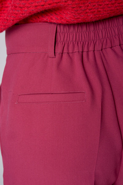 Short rose de TERRE BLEUE, avec taille élastique et une poche passepoilée à l'arrière.