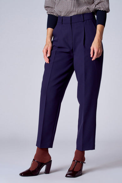Short bleu de TERRE BLEUE, porté avec un pull à motifs et des chaussures à talons marron avec des chaussettes assorties.
