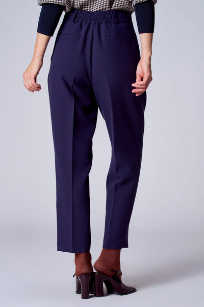 Short bleu de TERRE BLEUE, avec taille élastique, porté avec des chaussettes marron et des chaussures à talons.