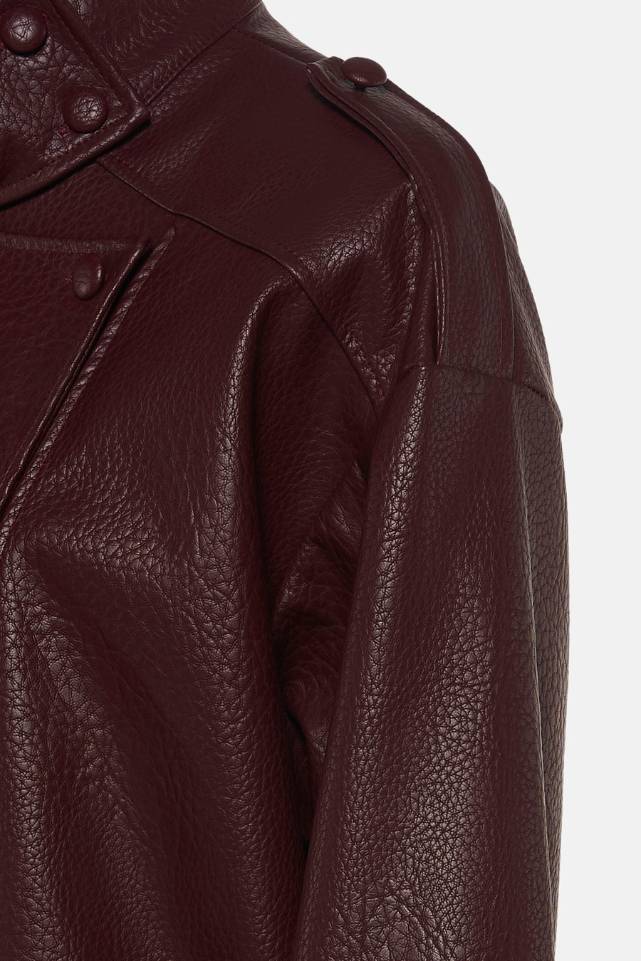 Bordeaux leather bomber jacket with textured surface and snap buttons, side view close-up