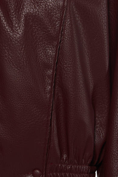 Bordeaux leather bomber jacket with textured surface and elasticated hem, close-up front view