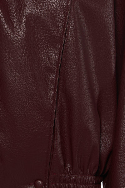 Bordeaux leather bomber jacket with textured surface and elasticated hem, close-up front view