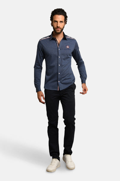 Blauwe broek van DELAHAYE, gedragen met een overhemd met knopen en witte sneakers.