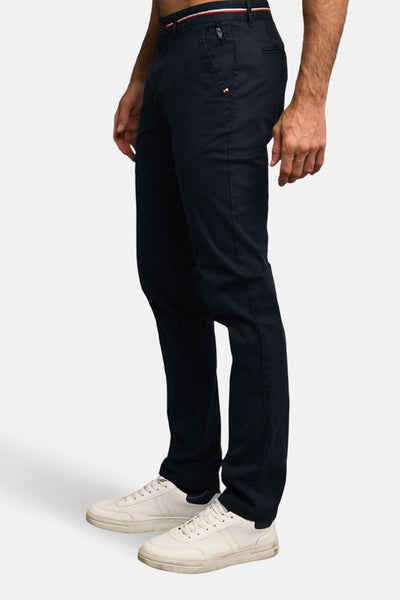 Pantalon bleu marine de DELAHAYE, coupe ajustée, détail tricolore à la taille, porté avec des baskets blanches.