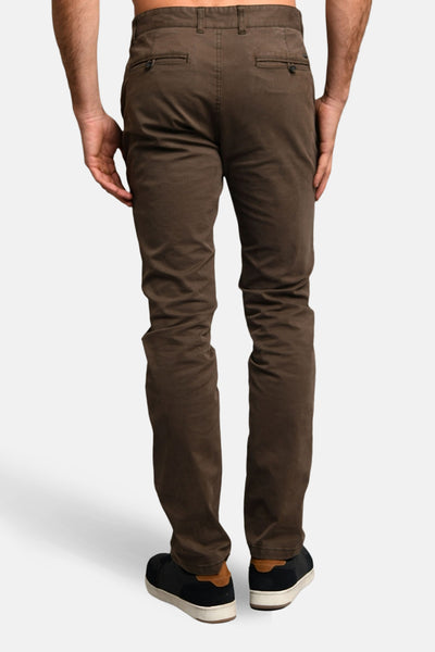 Pantalon marron de DELAHAYE, coupe slim, avec poches arrière boutonnées et chaussures de sport noires.