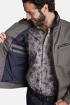Veste courte verte de DELAHAYE avec poches zippées et doublure intérieure bleu marine, portée sur une chemise à motifs floraux.