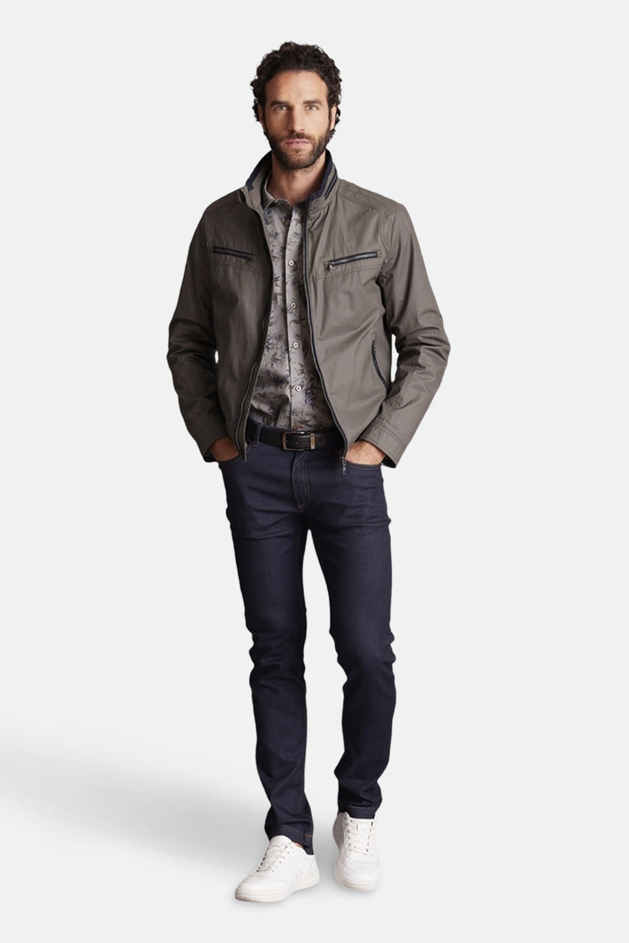 Veste courte verte par DELAHAYE, avec fermeture éclair, portée avec une chemise à motif et un jean bleu marine.