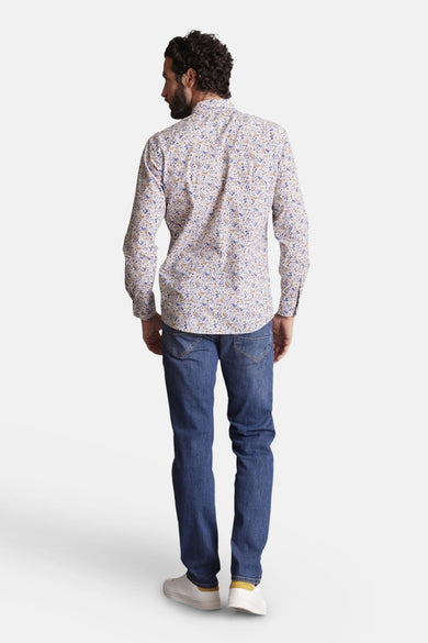 Chemise multicolore de DELAHAYE, à motif floral, portée avec un jean bleu et des chaussures blanches, vue de dos.
