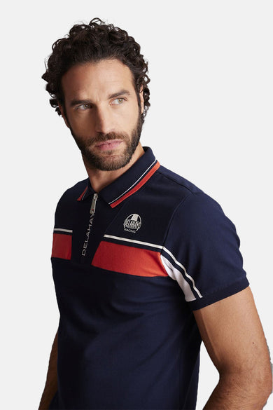 Polo à manches courtes bleu de DELAHAYE, avec fermeture éclair et rayures décoratives blanches et orange.