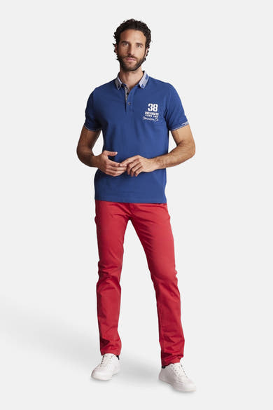 Rode broek van DELAHAYE, gedragen met een blauw polo en witte sneakers.