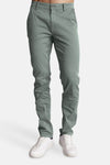 Pantalon vert de DELAHAYE, coupe ajustée, porté avec des chaussures de sport blanches.
