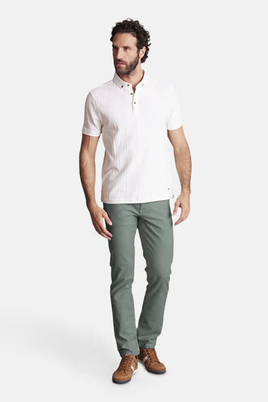 Pantalon vert par DELAHAYE, coupe classique, porté avec un polo blanc et des chaussures marron.