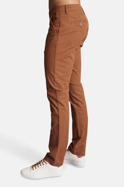 Bruine chino van DELAHAYE gedragen met witte sneakers, zijaanzicht.