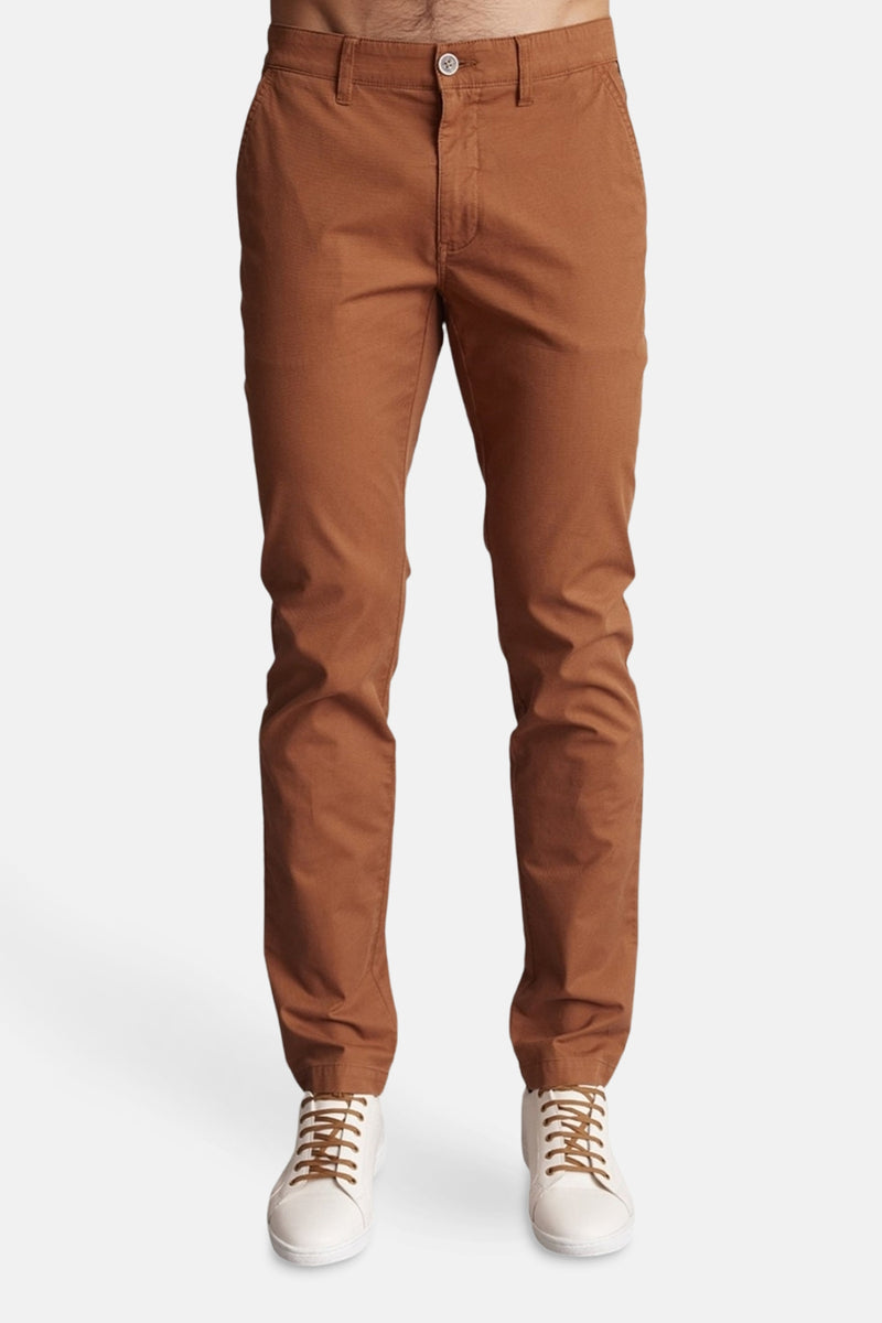 Bruine chino van DELAHAYE, gedragen met witte sportschoenen met bruine veters.
