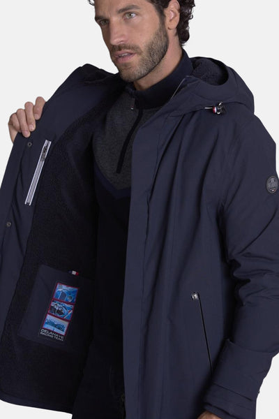 Veste longue bleue de DELAHAYE avec capuche et doublure en fausse fourrure, poche intérieure avec motif imprimé.