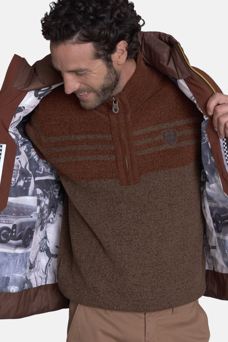 Bodywarmer marron avec doublure à motifs de voitures anciennes de DELAHAYE, porté avec un pull et un pantalon beige.